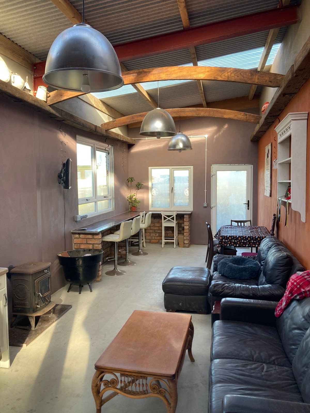Interior of a converted barn with exposed wooden beams and comfortable seating